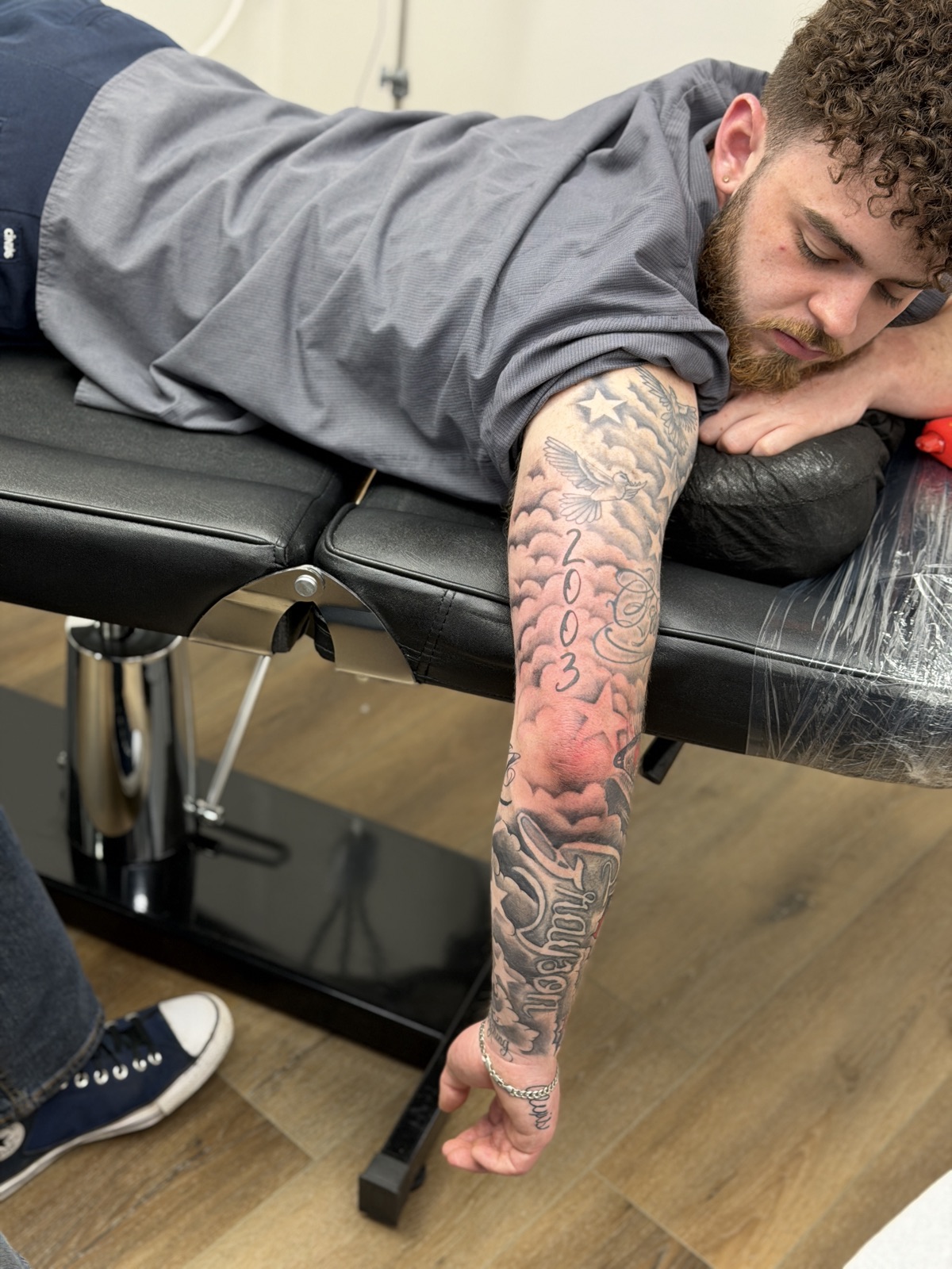Client in chair with cloud and lettering sleeve